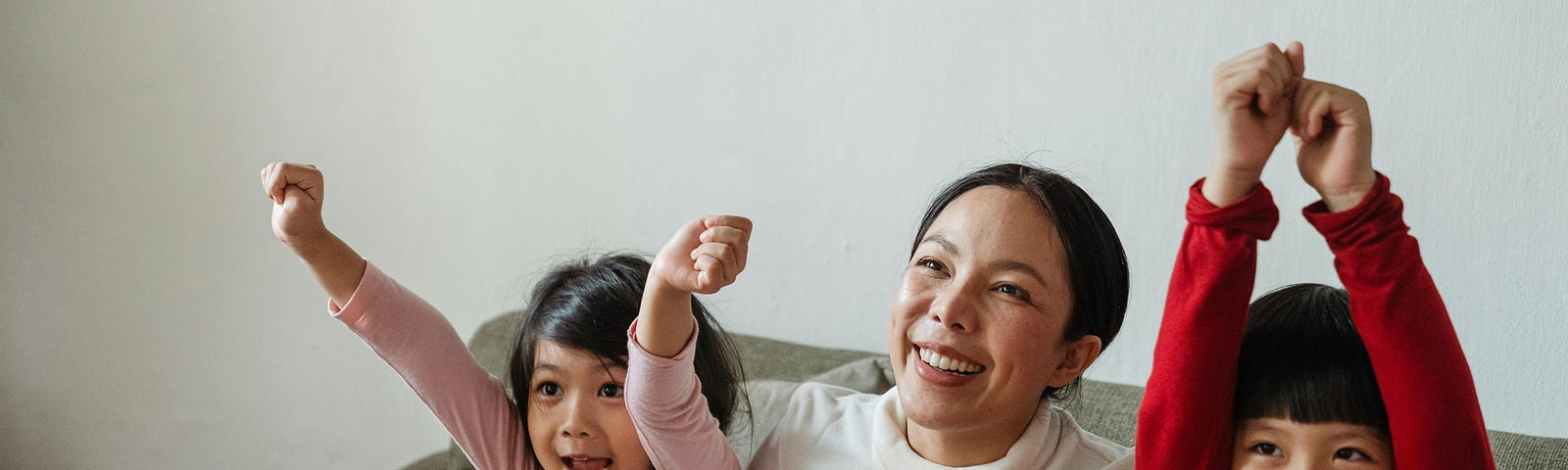 Happy Mom woman with kids cheering while watching TV