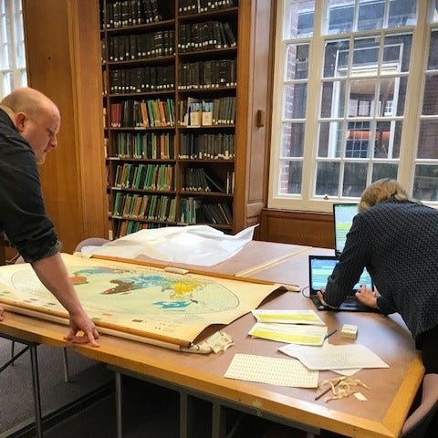 Two students looking at large map in special collections map room