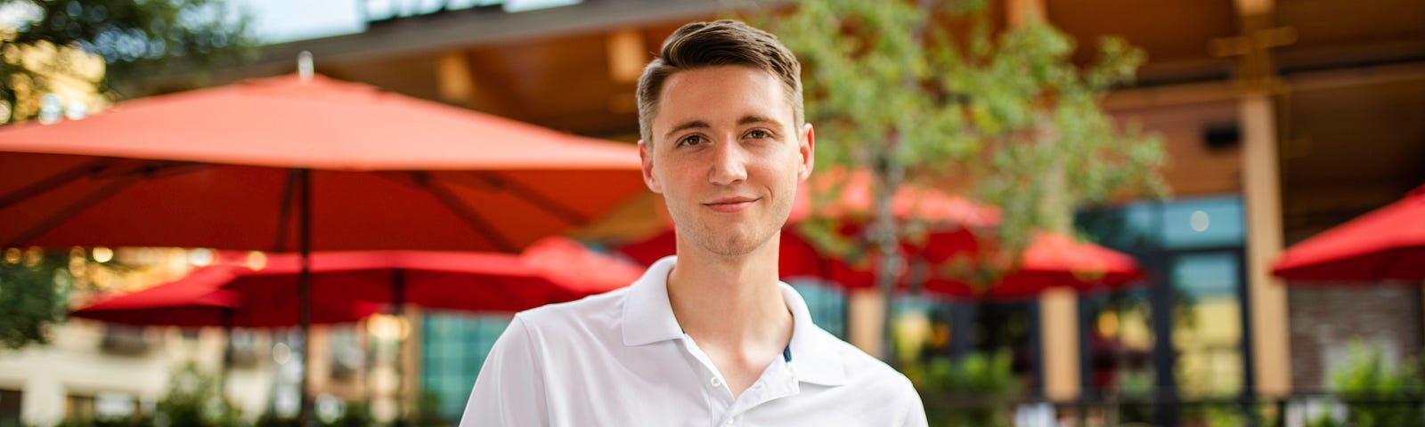 A guy in white polo staring at the camera