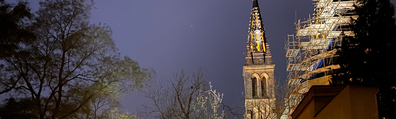 Night photo of a cobblestone street with a cathedral in the background