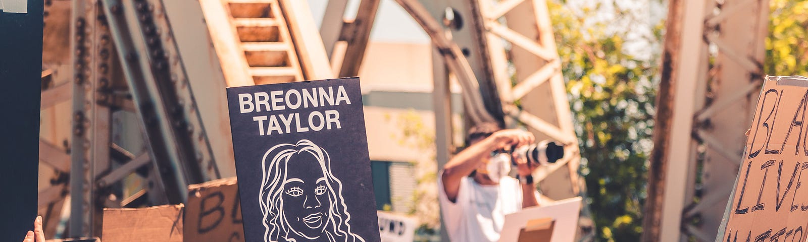 protestors with black and white signs, breonna taylor sign