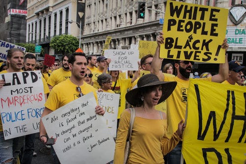 A photograph of white people marching with White People 4 Black Lives signs