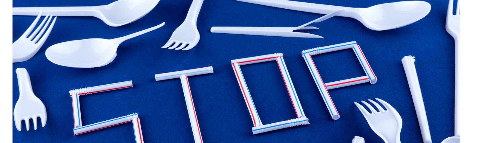 Plastic cutlery surrounding the word STOP spelt out using plastic straws.