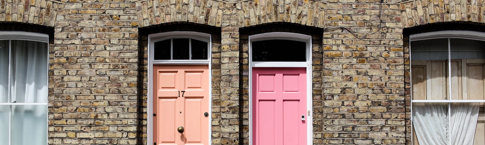 Two doors taken at Columbia Rd. One is beige and the other one is light pink.