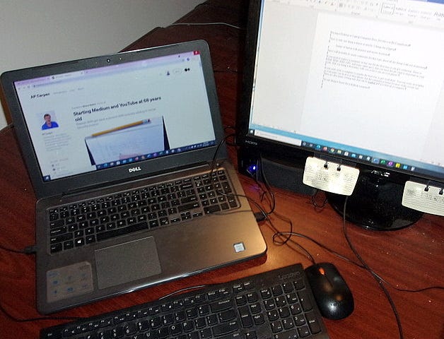 A computer laptop with two monitors