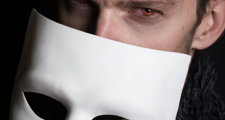 Man with mysterious look holding a white mask