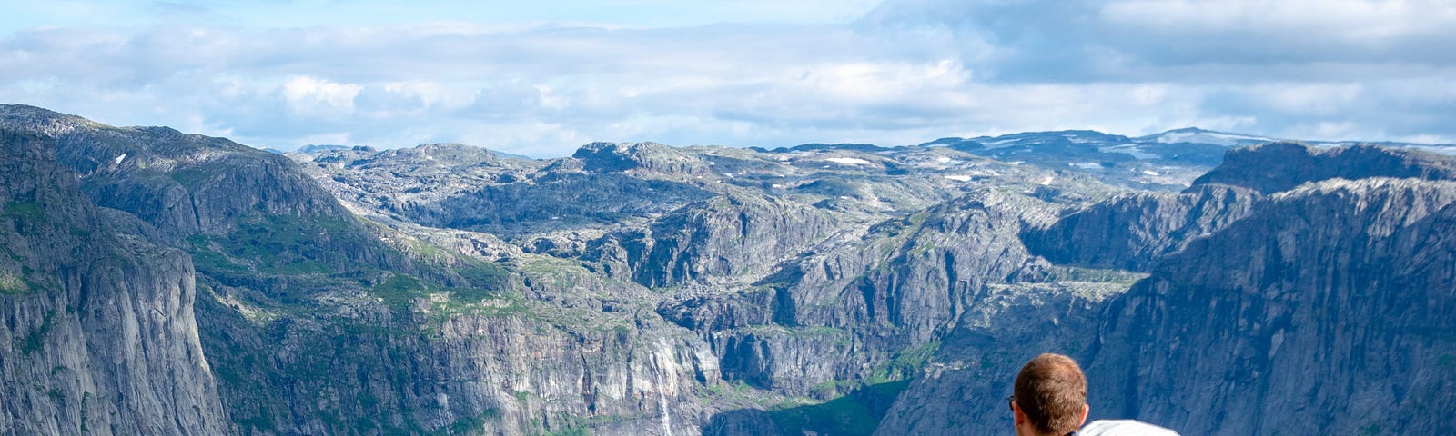 A mountain hiker watching the panorama and the paths behind and in front of them.