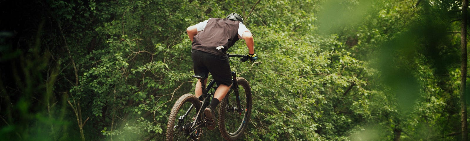 A man on a bike hitting a jump.