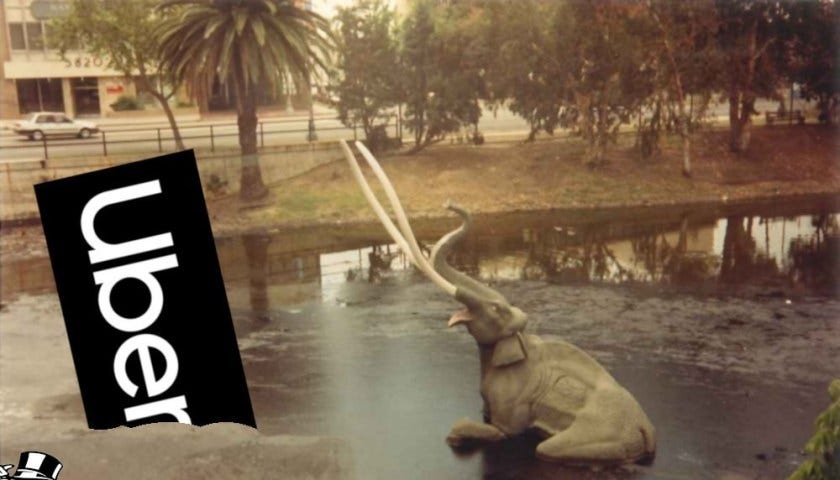 The sinking mammoth exhibition at the La Brea Tar Pits; next to the doomed pachyderm is the Uber logo, also mired in the tar. Monopoly’s Rich Uncle Pennybags is partially in the bottom left corner of the frame, running away with a bag of money. Image: Tarcil (modified) CC BY-SA: https://creativecommons.org/licenses/by-sa/4.0/deed.en