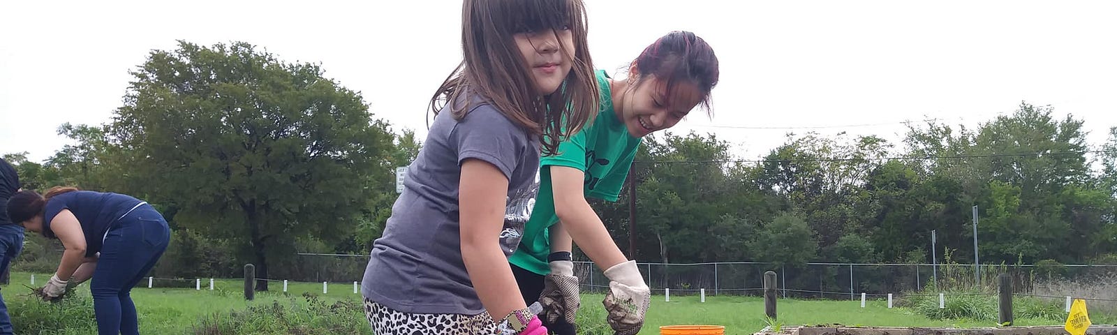 Two little girls dig in a school garden at Pleasant Hill Elementary in South Austin.
