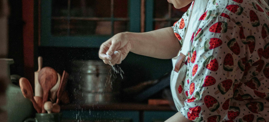 woman dusting flour over table