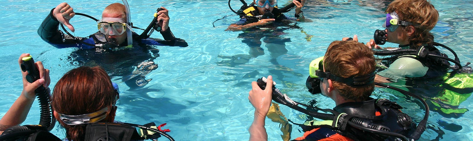 A scuba diving instructor leading a class in pool exercises.