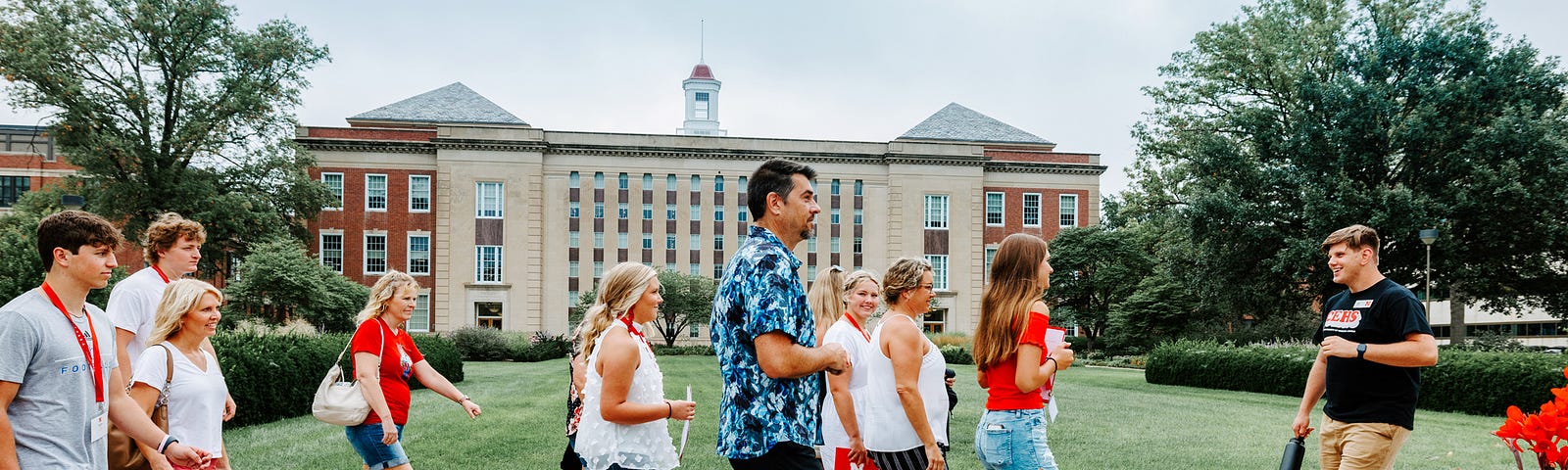 A campus host leads a group of prospective students and their families past Love Library