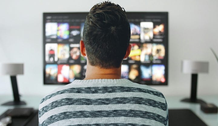 Man in front of movie streamng selections.