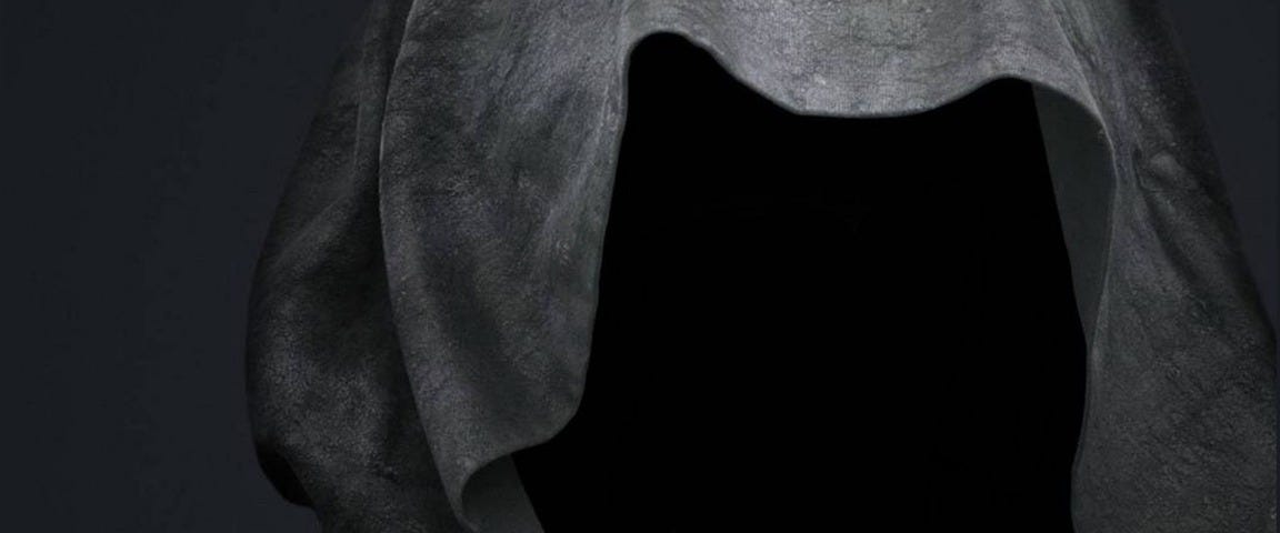 A hooded figure with a dark void for a face