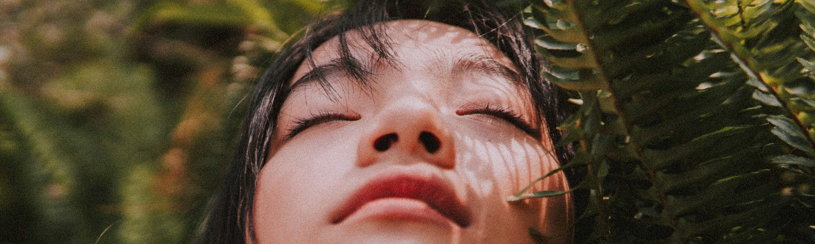 close up of a girl and her eyes closed embracing mother nature around her