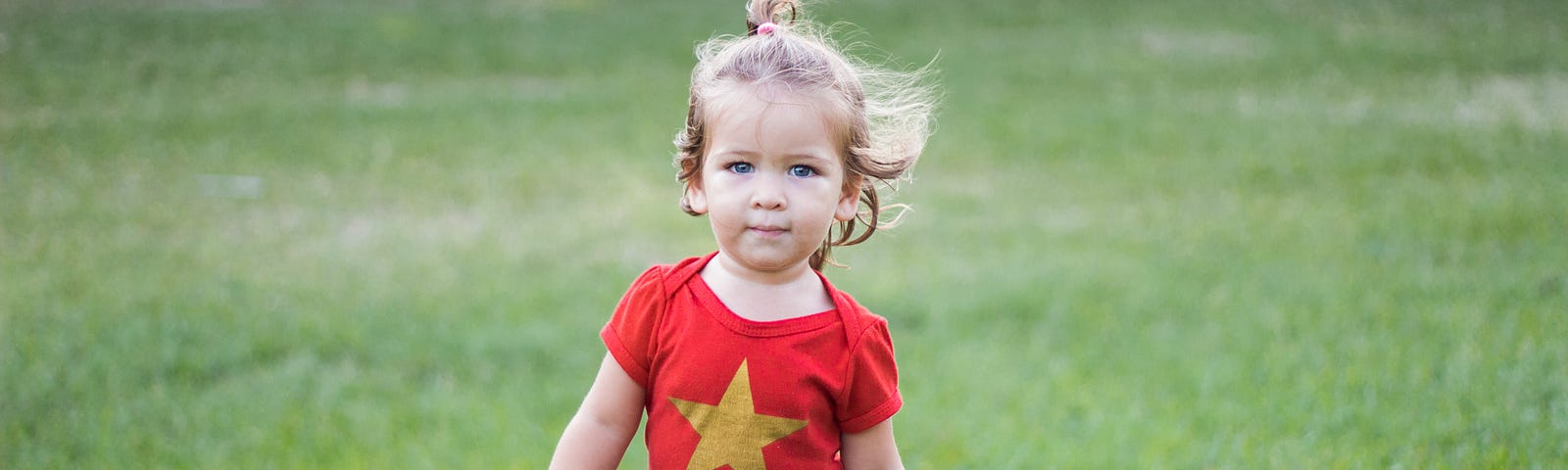 girl, walking through grassy field, in wonder woman costume