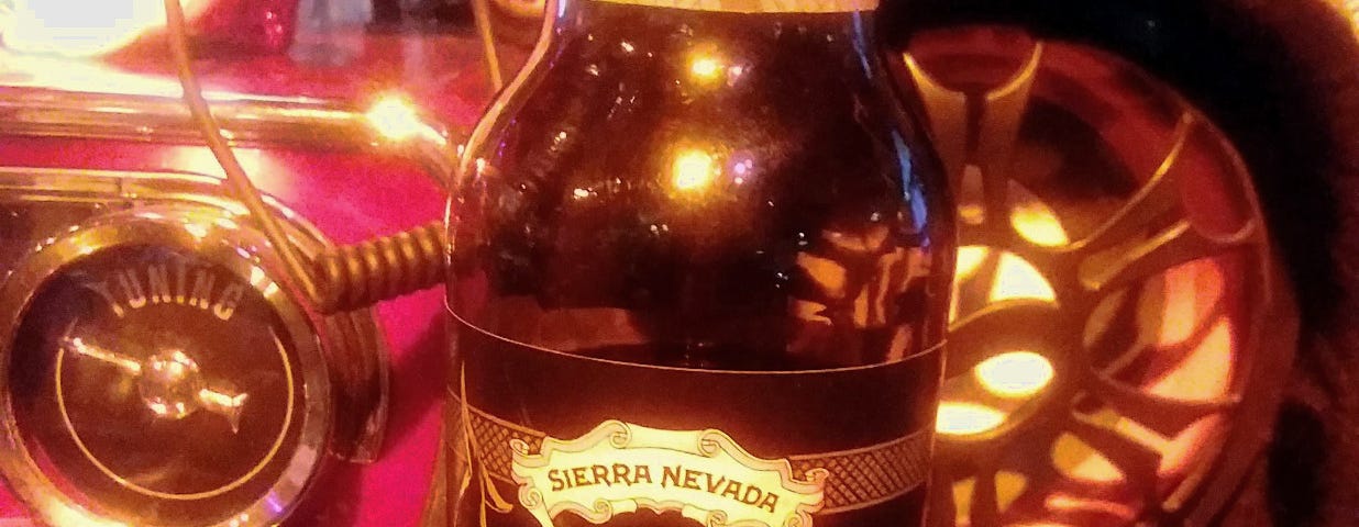 Picture of a dark beer, a stout, on the counter of a dark bar.