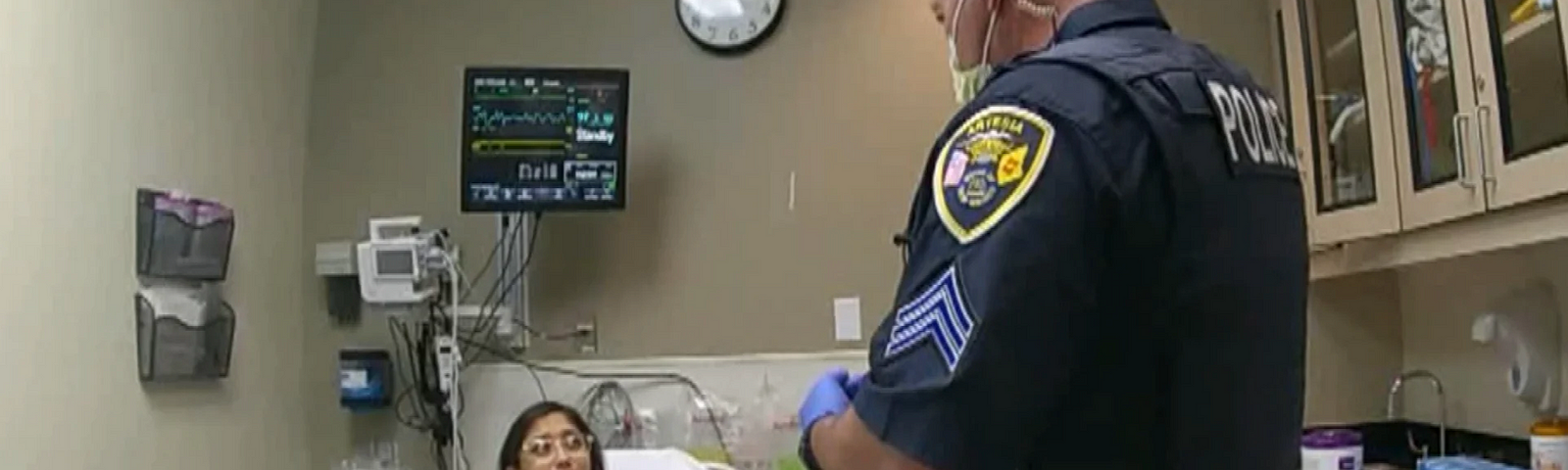 Police talking to a woman in a hospital bed