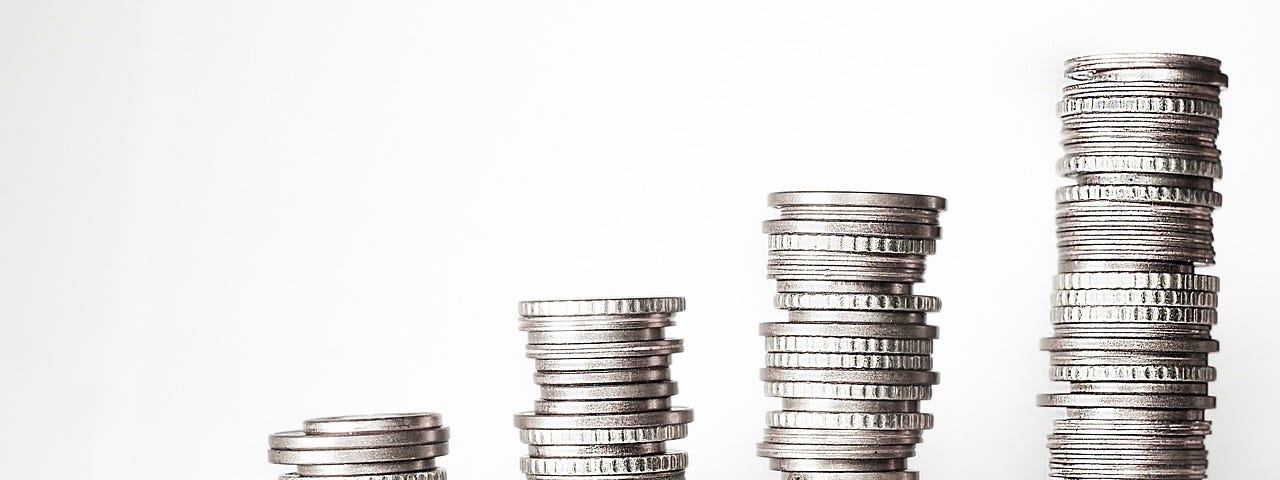 Five stacks of coins, increasing in height from left to right, highlighting the impact of income inequality.