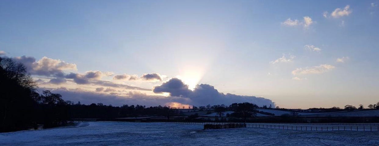 A picturesque view of a frosted over field at dusk