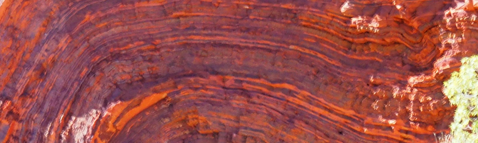 Rust red sedimentary layers, folded like a swirl of whipped cream
