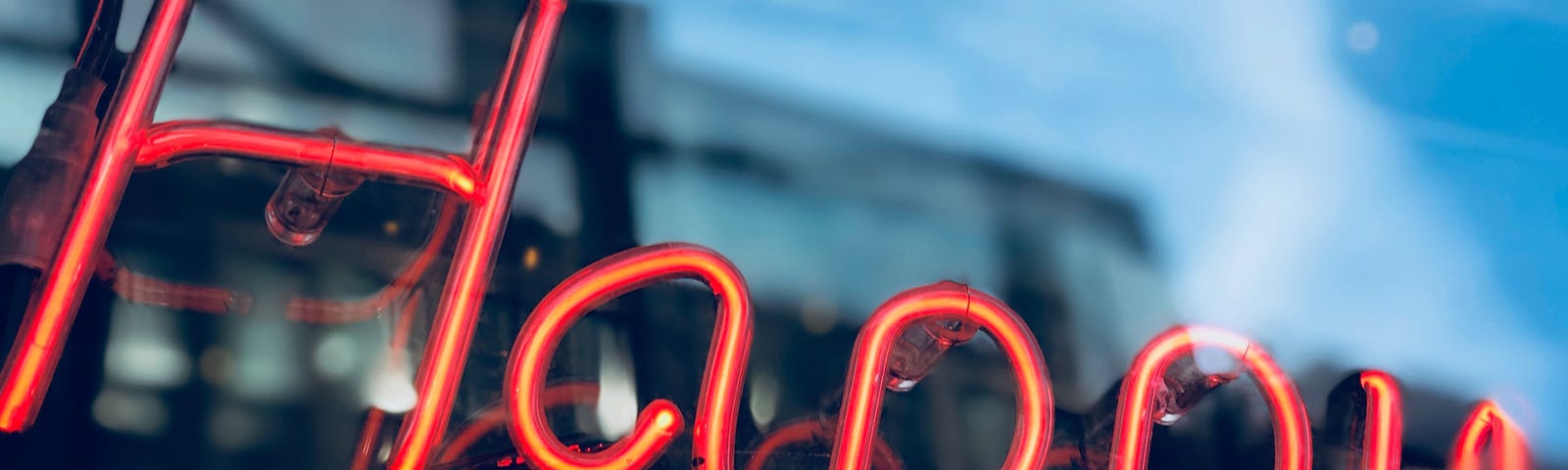 red neon sign that says ‘happy’