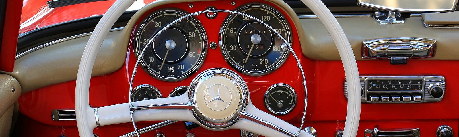 Retro white steering wheel on a red dash borad.