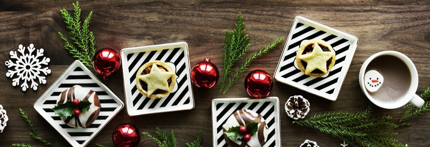 Image: A holiday spread of desserts, ornaments, and pine cones.