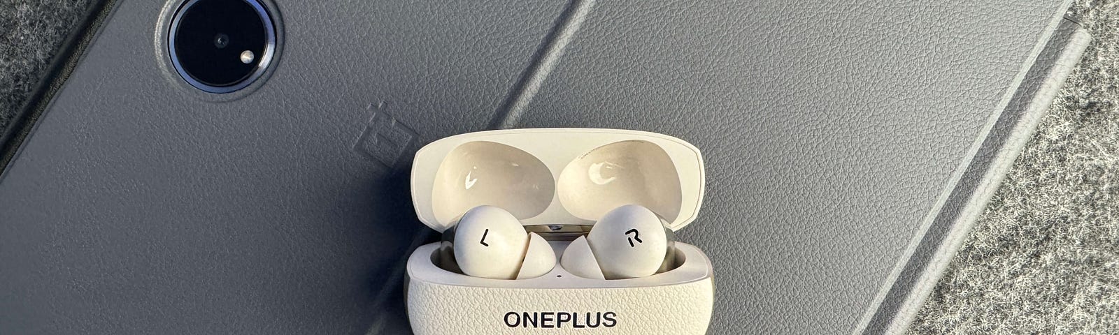 OnePlus Buds Pro 3 in case on top of a tablet.