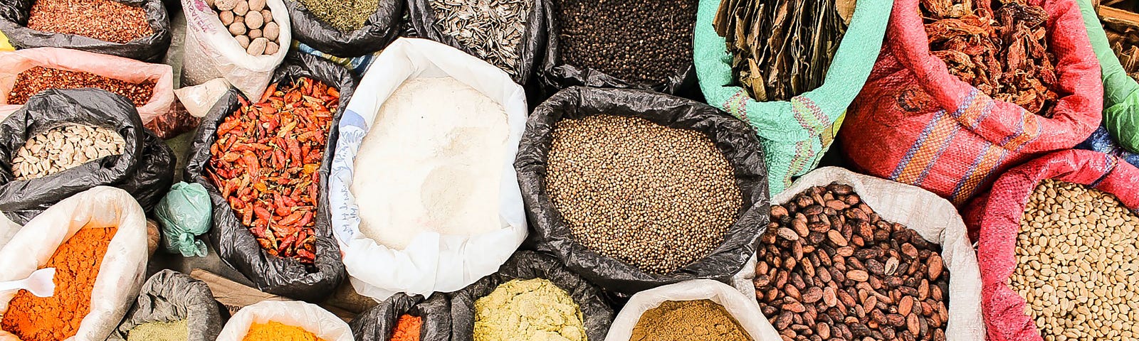 The picture shows an abundance of colorful spices and seeds in a variety of bags.