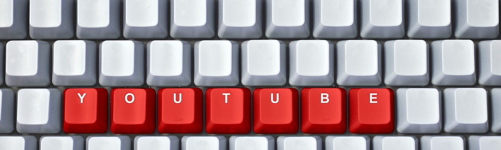 Computer keyboard showing red keys spelling Youtube