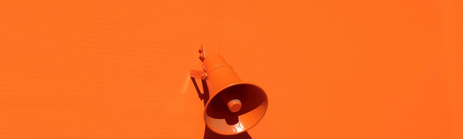Orange megaphone on orange wall