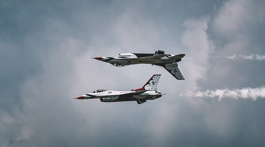 Two jets flying against cloudy sky
