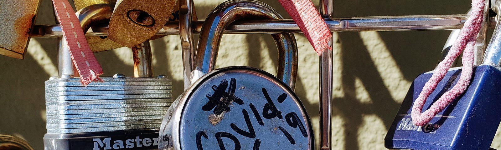 Picture of a lock on a gate that reads “COVID19 never lose hope”