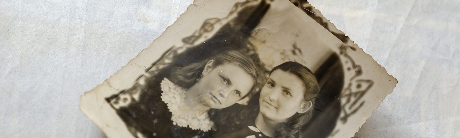 Black and white image of two sisters posing in a vintage 1900s photo