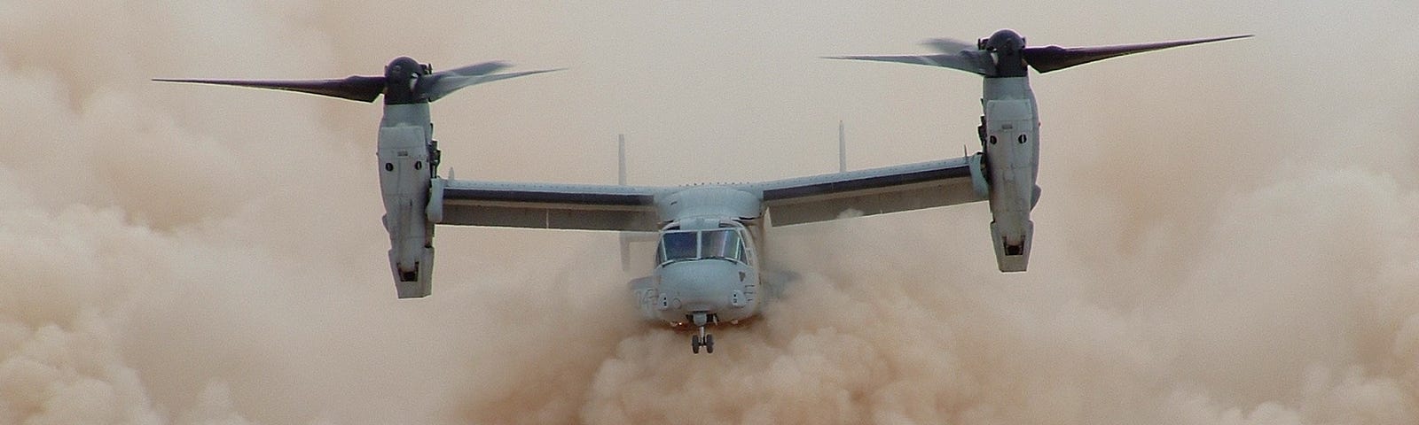 A CV-22 aircraft flying in a dust cloud.