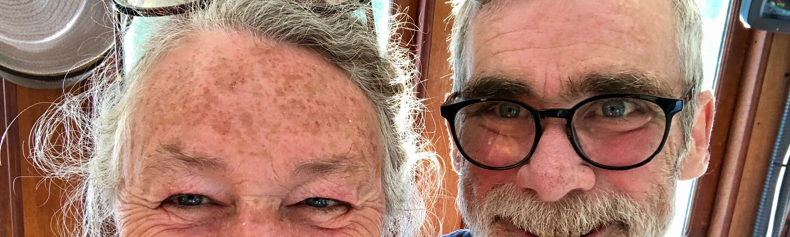 Two faces appear in the photo. Both are seniors with grey hair and both are smiling.