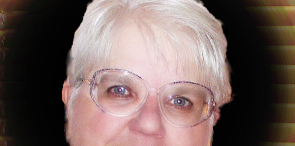 self portrait of Bonnie Doebley, blue eyes, white hair, round face woth glasses