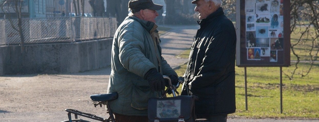 two elderly men talking on the street