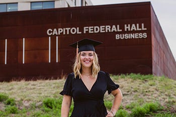 Meredith Rivas is pictured in her graduation cap in front of the exterior of Capitol Federal Hall