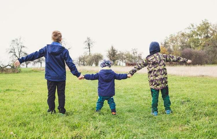 A mom and her two boys staring at the sky.