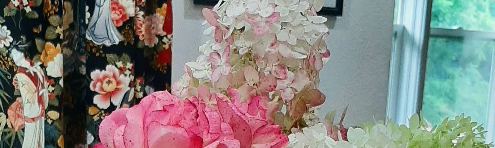 Arrangement of white, green, and blush hydrangeas and pink roses.