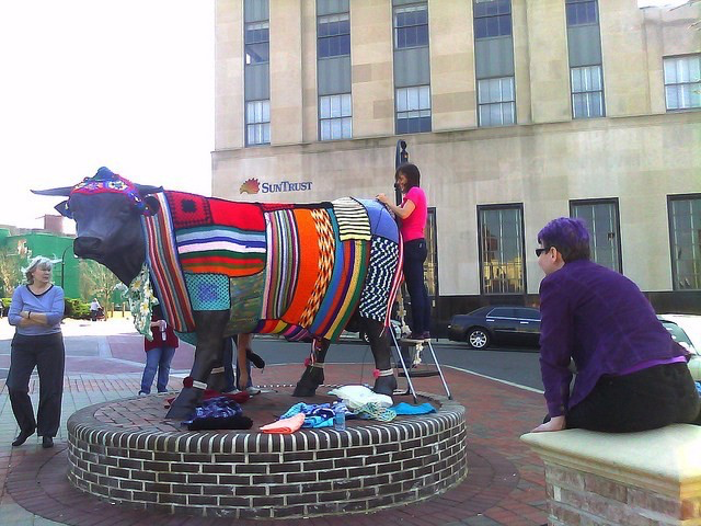 Me, Leslie Stahlhut, doing some final seaming on a yarn bombing of Major Bull in downtown Durham, North Carolina