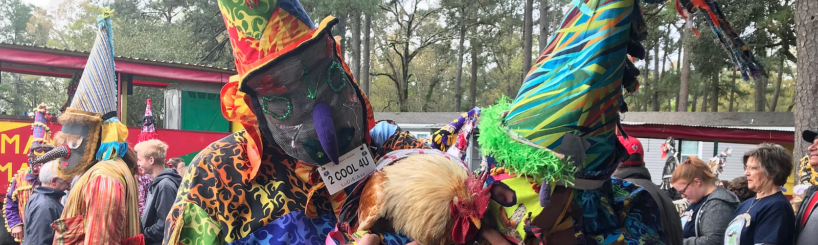 Cajun men celebrating Mardi Gras in Tee Mamou Louisiana, in colorful raggedy costumes. Two are holding up an exhausted rooster they had chased in a game.