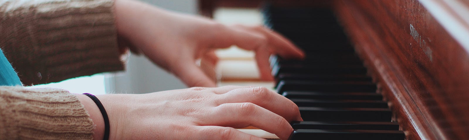 Hands playing on a piano keyboard