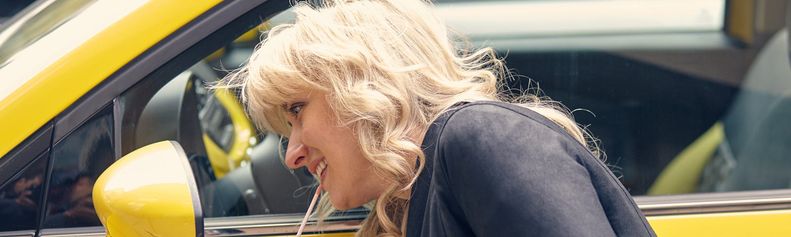 young-attractive-blond-woman-paints-her-lips-looking-side-mirror-yellow-car — Un Swede