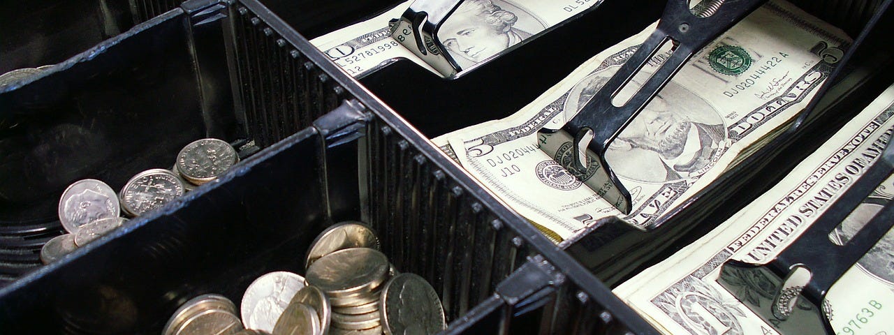 IMAGE: An open cash register showing coins and bills