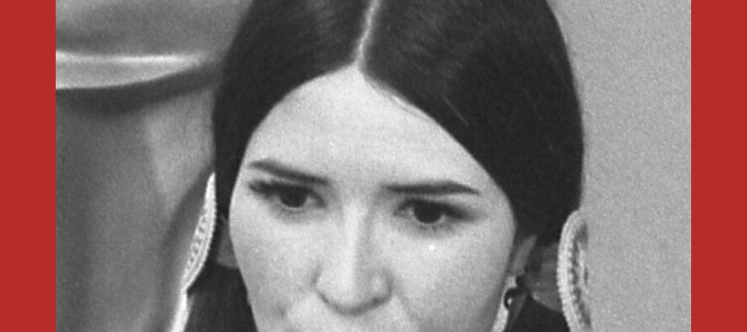 Close up of Native American activist and actor, Sacheen Littlefeather at the 1973 Academy Awards. Gold Oscar statue in the background