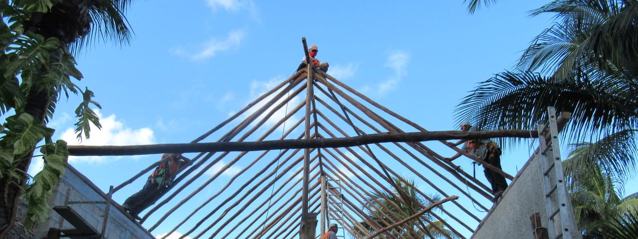 Palaperos laying the poles in place for a palapa home